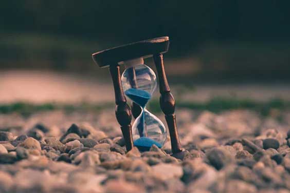 An hourglass on a rocky surface